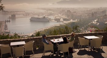 Movie still from “The Trip to Spain” (2017), directed by Michael Winterbottom – A group of people sitting at a table on top of a hill; Extreme Wide shot, High angle