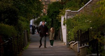 Movie still from “The Trip to Spain” (2017), directed by Michael Winterbottom – A man and a little girl walking down a sidewalk; Wide shot, Over the shoulder angle