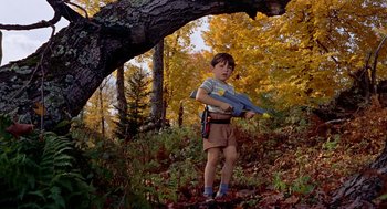 Movie still from “The Trouble with Harry” (1955), directed by Alfred Hitchcock – A young boy holding a toy gun in the woods; Medium shot, High angle