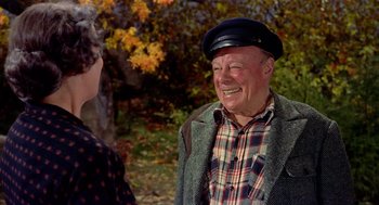 Movie still from “The Trouble with Harry” (1955), directed by Alfred Hitchcock – An older man wearing a hat talking to an older woman; Medium shot, Over the shoulder angle