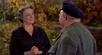 Movie still from “The Trouble with Harry” (1955), directed by Alfred Hitchcock – An older man and woman talking in a park; Medium shot, Over the shoulder angle