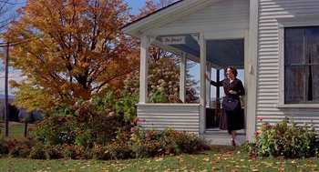 Movie still from “The Trouble with Harry” (1955), directed by Alfred Hitchcock – A woman standing on the porch of a house; Wide shot, Low angle