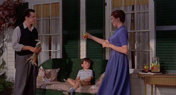 Movie still from “The Trouble with Harry” (1955), directed by Alfred Hitchcock – A woman and a boy sitting on a green couch; Wide shot, Low angle