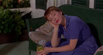 Movie still from “The Trouble with Harry” (1955), directed by Alfred Hitchcock – A woman sitting on a couch holding a glass of juice; Close Up shot, High angle