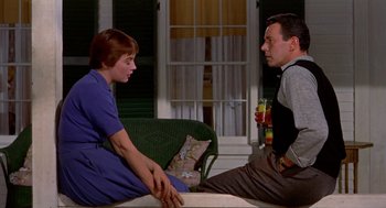 Movie still from “The Trouble with Harry” (1955), directed by Alfred Hitchcock – A man and a woman sitting on a couch with a drink; Medium shot, Low angle