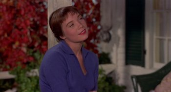 Movie still from “The Trouble with Harry” (1955), directed by Alfred Hitchcock – A woman in a purple shirt sitting on a porch; Close Up shot, Low angle