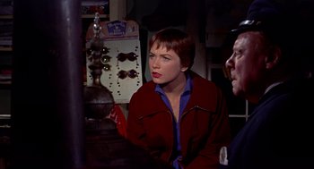 Movie still from “The Trouble with Harry” (1955), directed by Alfred Hitchcock – A woman sitting next to a man wearing a red jacket; Medium shot, Over the shoulder angle