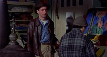 Movie still from “The Trouble with Harry” (1955), directed by Alfred Hitchcock – A man wearing a brown jacket and a brown hat; Medium shot, Over the shoulder angle