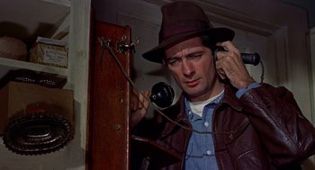 Movie still from “The Trouble with Harry” (1955), directed by Alfred Hitchcock – A man wearing a hat is talking on a phone; Close Up shot, Low angle