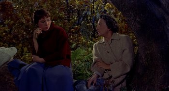 Movie still from “The Trouble with Harry” (1955), directed by Alfred Hitchcock – Two women sitting on a bench in the woods; Medium shot, High angle