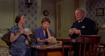 Movie still from “The Trouble with Harry” (1955), directed by Alfred Hitchcock – A group of people sitting at a table playing cards; Medium shot, High angle