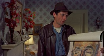 Movie still from “The Trouble with Harry” (1955), directed by Alfred Hitchcock – A man wearing a hat and a leather jacket looking at a painting; Close Up shot, Over the shoulder angle
