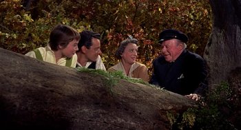 Movie still from “The Trouble with Harry” (1955), directed by Alfred Hitchcock – A group of people gathered around a tree trunk; Medium shot, High angle