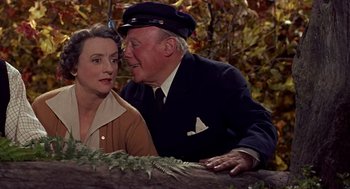 Movie still from “The Trouble with Harry” (1955), directed by Alfred Hitchcock – An older man and a younger woman sitting next to each other; Close Up shot, High angle