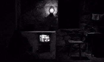 Movie still from “The Turin Horse” (2011), directed by Ágnes Hranitzky – A black and white photo of a television in a room; Wide shot, High angle