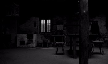 Movie still from “The Turin Horse” (2011), directed by Ágnes Hranitzky – An empty room with a table and a window; Wide shot, Low angle