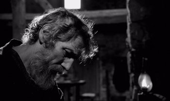 Movie still from “The Turin Horse” (2011), directed by Ágnes Hranitzky – A man with a beard is looking down at his face; Close Up shot, Over the shoulder angle