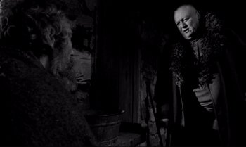 Movie still from “The Turin Horse” (2011), directed by Ágnes Hranitzky – A man with a long beard and a man with a beard and a man with long hair; Medium shot, Over the shoulder angle