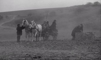 Movie still from “The Turin Horse” (2011), directed by Ágnes Hranitzky – A black and white photo of a horse drawn carriage; Wide shot, High angle