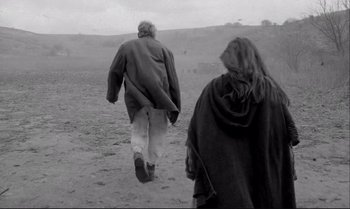 Movie still from “The Turin Horse” (2011), directed by Ágnes Hranitzky – A man and a woman are walking through the desert; Wide shot, Low angle
