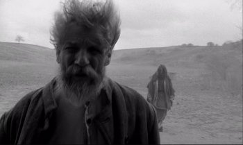 Movie still from “The Turin Horse” (2011), directed by Ágnes Hranitzky – A man and a woman walking in the desert; Medium shot, Low angle
