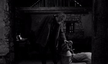 Movie still from “The Turin Horse” (2011), directed by Ágnes Hranitzky – An old man is holding something in his hand; Wide shot, High angle