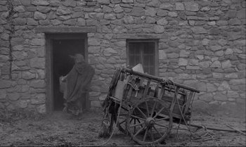 Movie still from “The Turin Horse” (2011), directed by Ágnes Hranitzky – An old photo of a man and a cart in front of a house; Wide shot, Over the shoulder angle