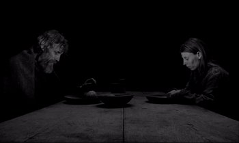 Movie still from “The Turin Horse” (2011), directed by Ágnes Hranitzky – A man and a woman sitting at a dinner table; Medium shot, High angle