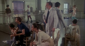 Movie still from “The Turning Point” (1977), directed by Herbert Ross – A group of people standing around in a room; Medium shot, Over the shoulder angle