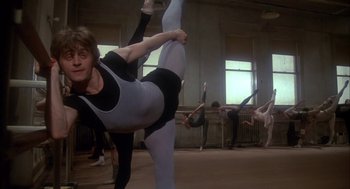 Movie still from “The Turning Point” (1977), directed by Herbert Ross – A woman is doing an acrobatic move in a dance studio; Wide shot, Low angle