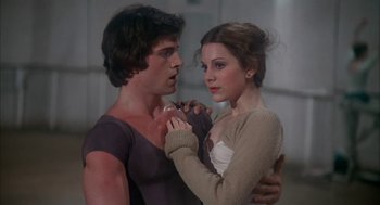 Movie still from “The Turning Point” (1977), directed by Herbert Ross – A man and a woman holding each other in a room; Close Up shot, Low angle
