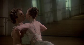 Movie still from “The Turning Point” (1977), directed by Herbert Ross – A man and a woman in a white dress dance; Close Up shot, Low angle