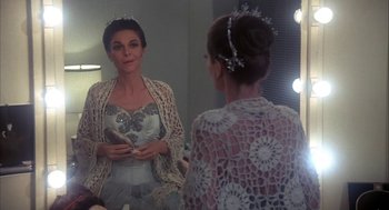 Movie still from “The Turning Point” (1977), directed by Herbert Ross – A woman is looking in the mirror wearing a tiara; Medium shot, Over the shoulder angle