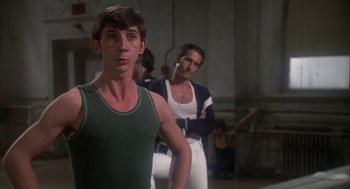 Movie still from “The Turning Point” (1977), directed by Herbert Ross – A man standing next to another man in a room; Close Up shot, Over the shoulder angle