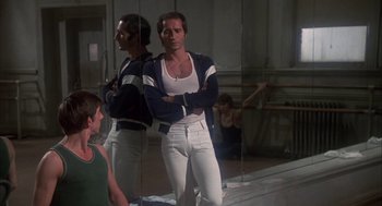 Movie still from “The Turning Point” (1977), directed by Herbert Ross – A man standing in front of a mirror with his arms crossed; Medium shot, Low angle