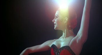 Movie still from “The Turning Point” (1977), directed by Herbert Ross – A woman in a red and black dress with a flower in her hair; Close Up shot, Low angle