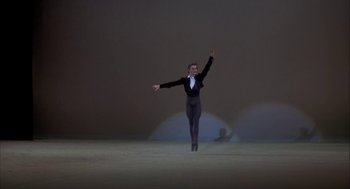 Movie still from “The Turning Point” (1977), directed by Herbert Ross – A man in a black suit is dancing on a stage; Wide shot, Low angle