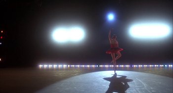 Movie still from “The Turning Point” (1977), directed by Herbert Ross – A woman in a red dress is dancing on a stage; Extreme Wide shot, Low angle