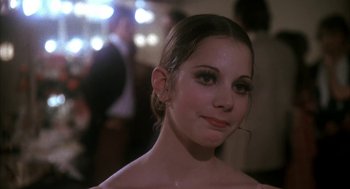 Movie still from “The Turning Point” (1977), directed by Herbert Ross – A young woman in a white dress is posing for a picture; Close Up shot, Low angle