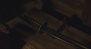 A sword is shown on a wooden surface