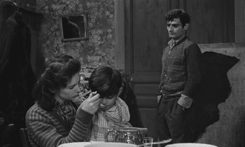 Movie still from “The Two of Us” (1967), directed by Claude Berri – An old photo of a man and a woman and a child; Medium shot, Over the shoulder angle