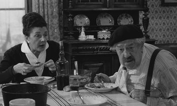 Movie still from “The Two of Us” (1967), directed by Claude Berri – A man and a woman sitting at a dinner table; Medium shot, High angle