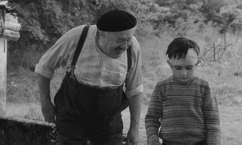 Movie still from “The Two of Us” (1967), directed by Claude Berri – An old man and a young boy standing next to each other; Medium shot, High angle