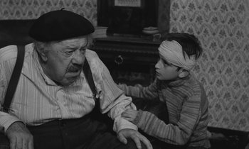 Movie still from “The Two of Us” (1967), directed by Claude Berri – An older man and a young boy are sitting together; Medium shot, Over the shoulder angle