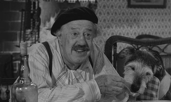 Movie still from “The Two of Us” (1967), directed by Claude Berri – An old man and a dog sitting at a table in a room; Close Up shot, High angle