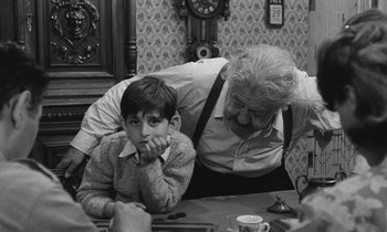Movie still from “The Two of Us” (1967), directed by Claude Berri – An older man and a young boy sitting at a table; Medium shot, Over the shoulder angle