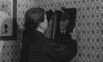 Movie still from “The Two of Us” (1967), directed by Claude Berri – A woman holding a framed picture of a man in a military uniform; Close Up shot, Over the shoulder angle