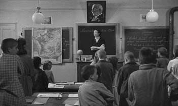 Movie still from “The Two of Us” (1967), directed by Claude Berri – An old photo of a man giving a lecture in a classroom; Wide shot, High angle