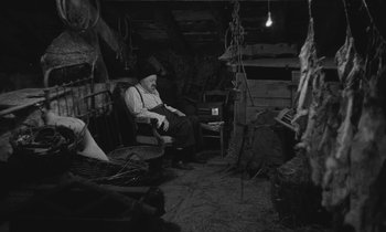 Movie still from “The Two of Us” (1967), directed by Claude Berri – An old man sitting on a chair in a room; Wide shot, High angle
