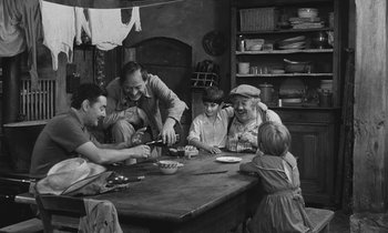 Movie still from “The Two of Us” (1967), directed by Claude Berri – A group of people sitting around a table; Medium shot, High angle